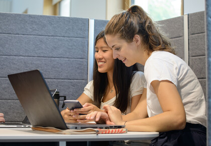 Zwei Studierende mit Laptops in Lernecke