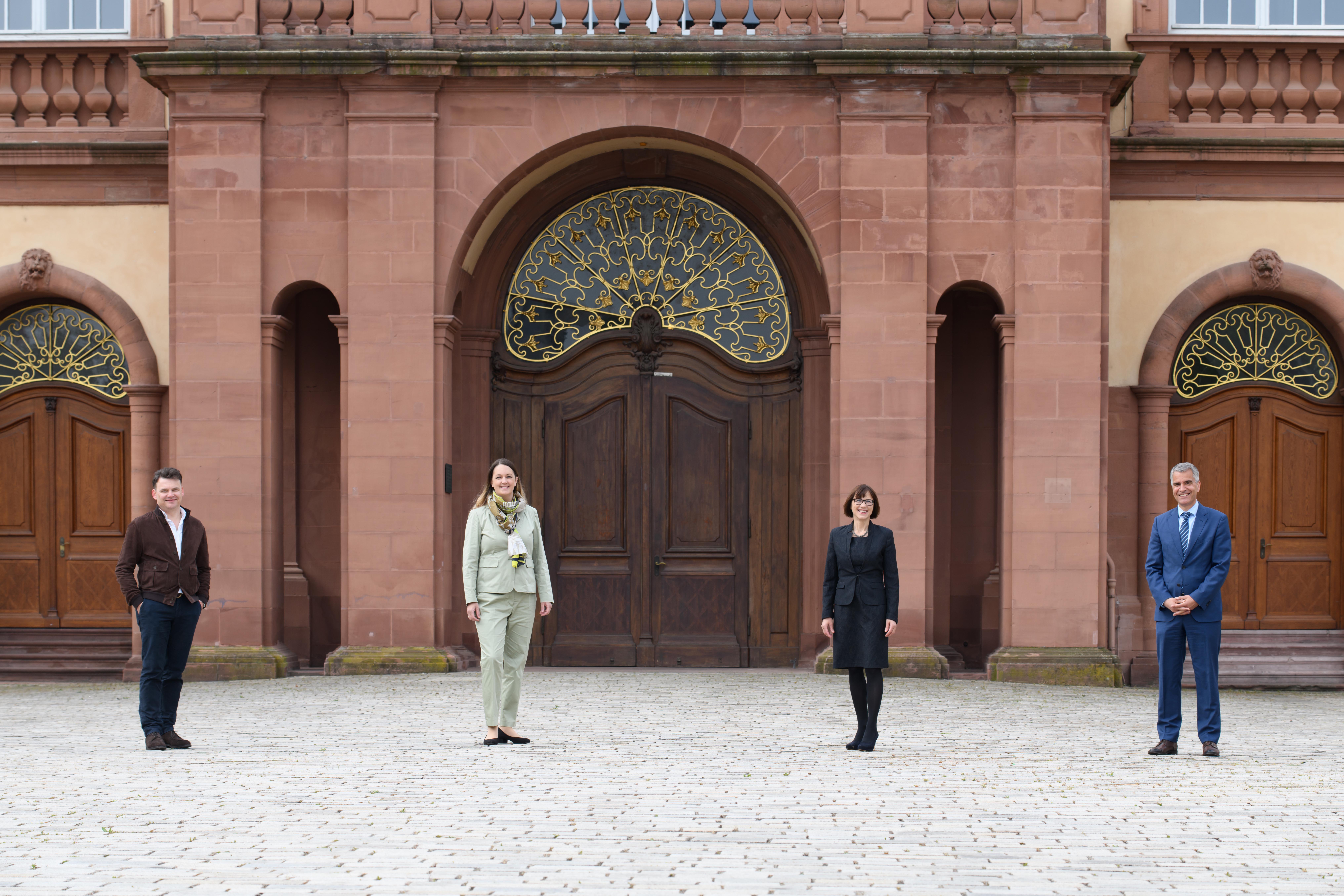 Vier Personen stehen im Innenhof des Mannheimer Schlosses.