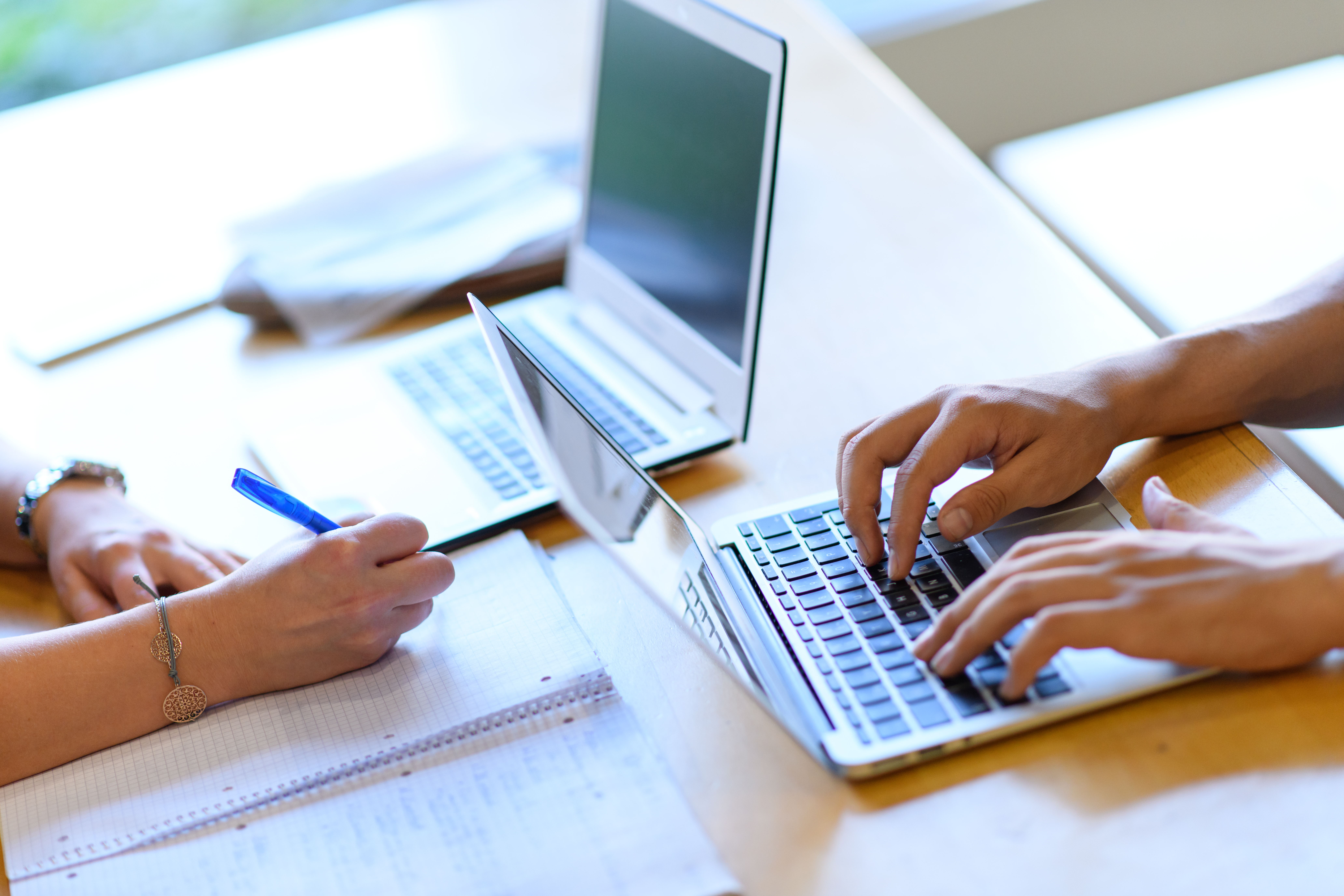 Ein Arbeitsplatz mit zwei Laptops, mit denen gearbeitet wird.