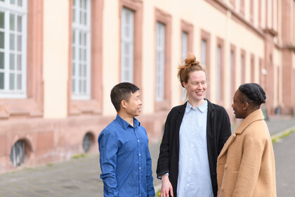 Drei Leute unterhalten sich vor Schloss