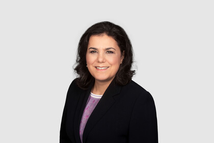 Prof. Aprea hat schulterlange dunkle Haare und trägt einen dunklen Blazer und eine lila Bluse.