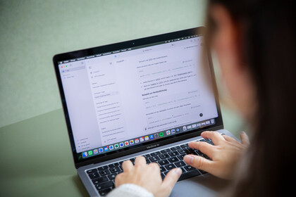 Hände, die auf einem Laptop tippen.