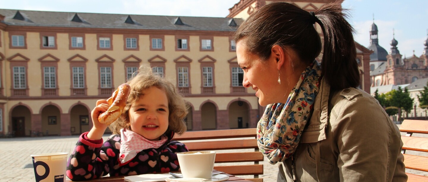Studentin und Kleinkind sitzen am Tisch