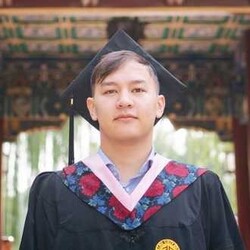 Markus Hanssler has short hair and wears a gown and a graduate's hat.