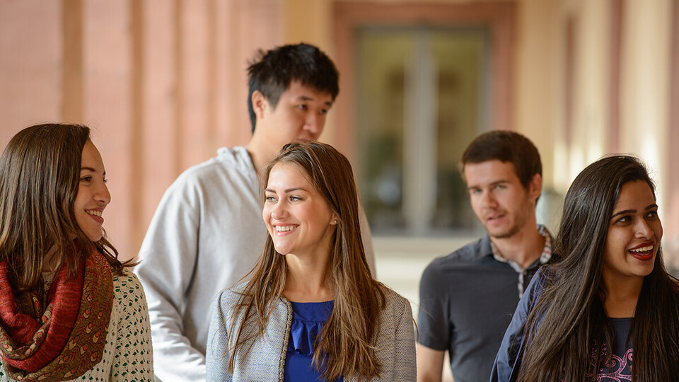 Fünf internationale Studierende stehen unter den Schlossarkaden.