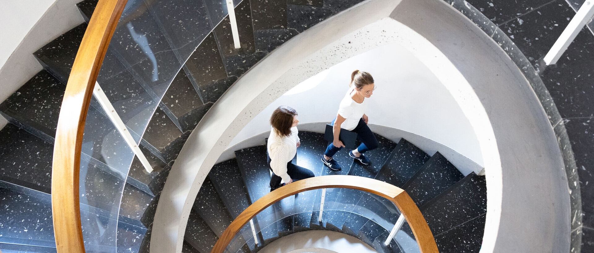 Zwei Forscher gehen eine Wendeltreppe im Barockschloss hinauf.