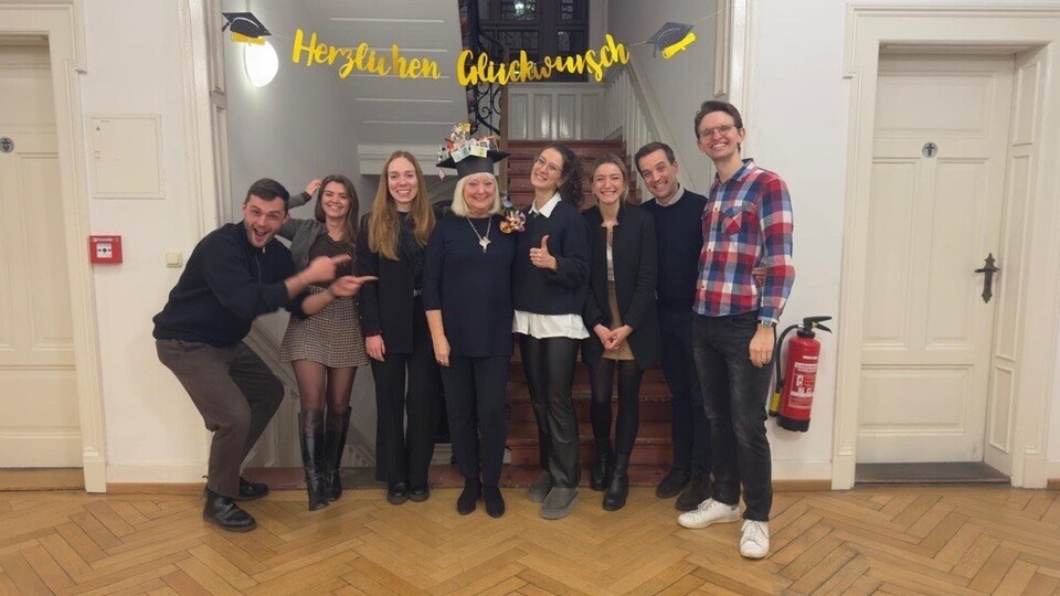 Das Team von LS Homburg steht vor dem Treppenhaus und Frau Scherer in der Mitte