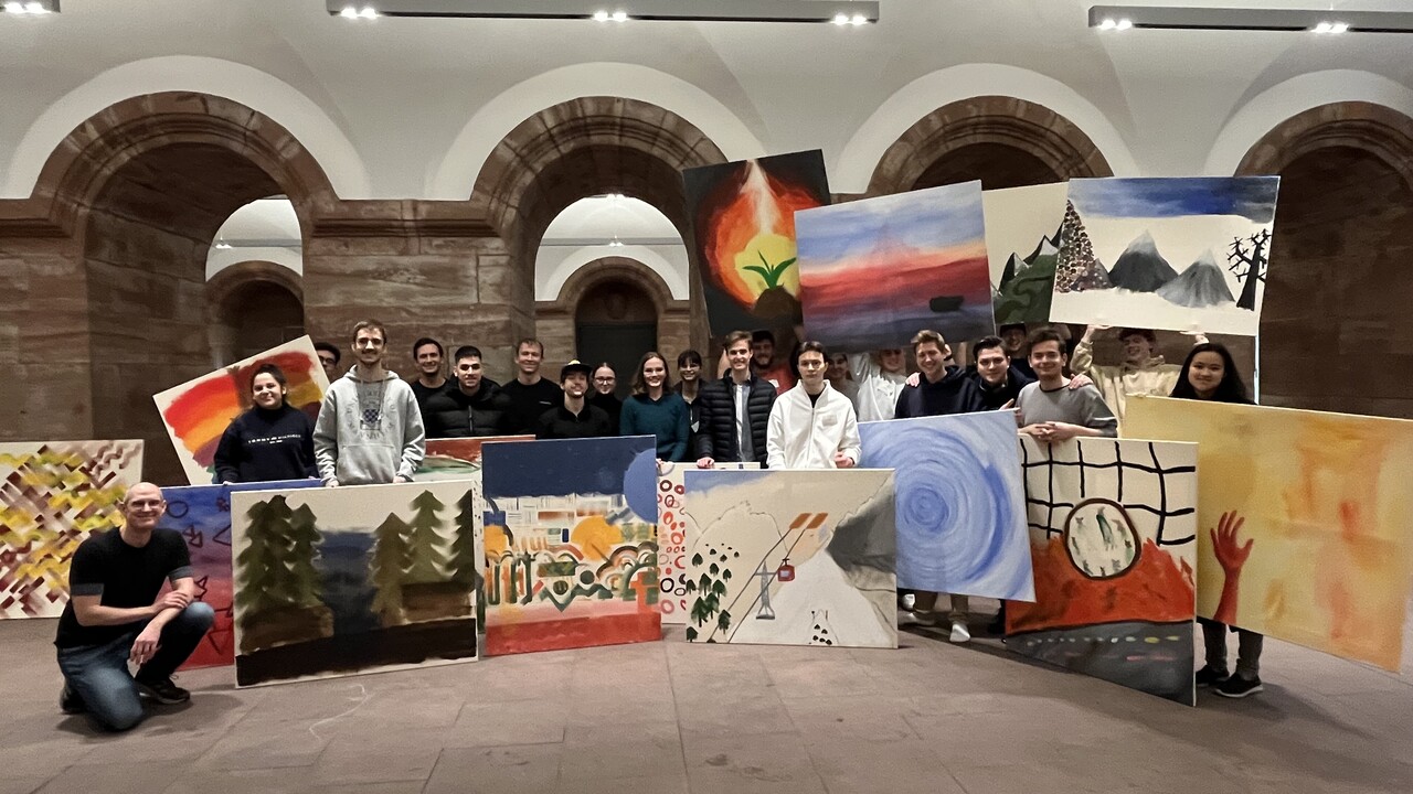 Gruppenfoto von Personen, die selbstgemalte Bilder vor sich halten.