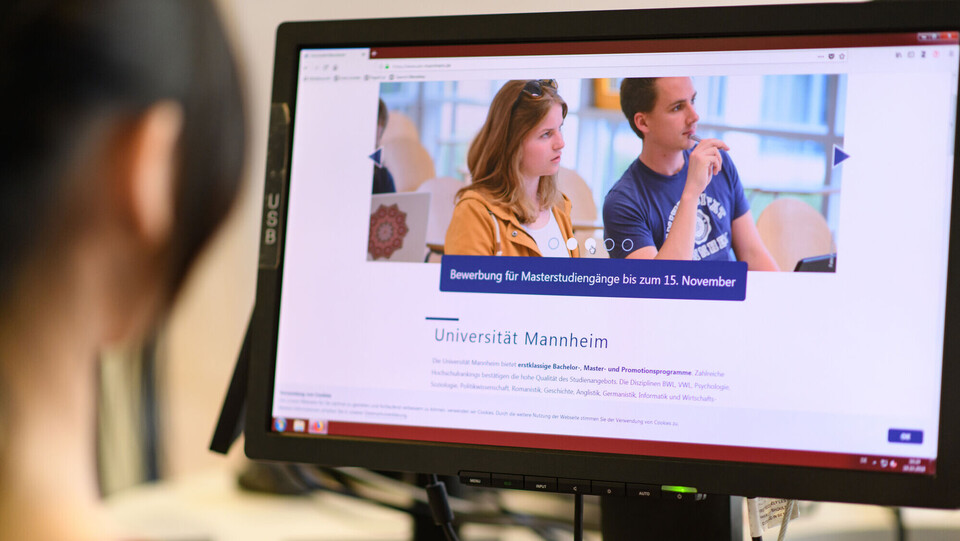 A5 Bibliothek Der Hinterkopf einer Studentin. Sie schaut auf einen Bildschirm.
