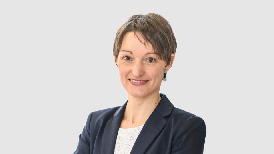 Prof. Bucher-Koenen hat kurze braune Haare und trägt einen dunkelblauen Anzug