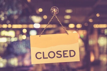 An einr Türe hängt ein Schild mit der Aufschrift "Closed".