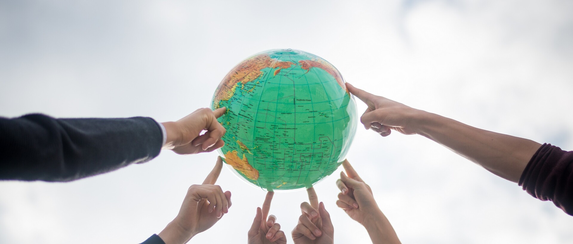 Hands point to globe