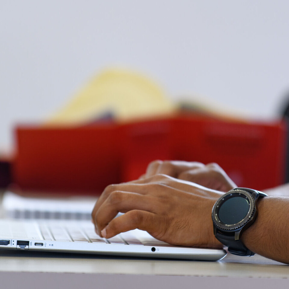 Zwei Hände tippen auf einer Tastatur.