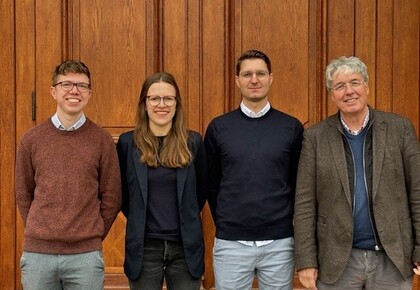 The M2Olie Research team, consisting of four persons, stands in front of the Mannheim Palace.