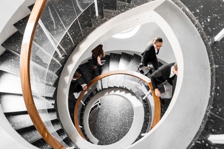 Bird's eye view of a black spiral staircase. Students walk up the stairs. Link: Career prospects