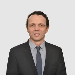 Prof. Ifenthaler hat dunkle Haare und eine Brille. Er trägt ein dunkles Jacket und eine gemusterte Krawatte.