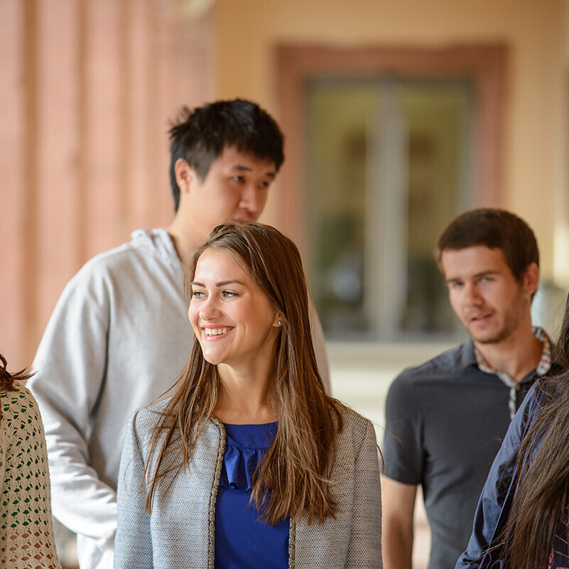 Fünf internationale Studierende stehen unter den Schlossarkaden.