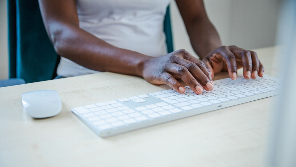 Person, die auf Computertastatur etwas tippt