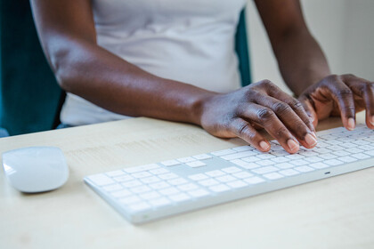 Person, die auf Computertastatur etwas tippt
