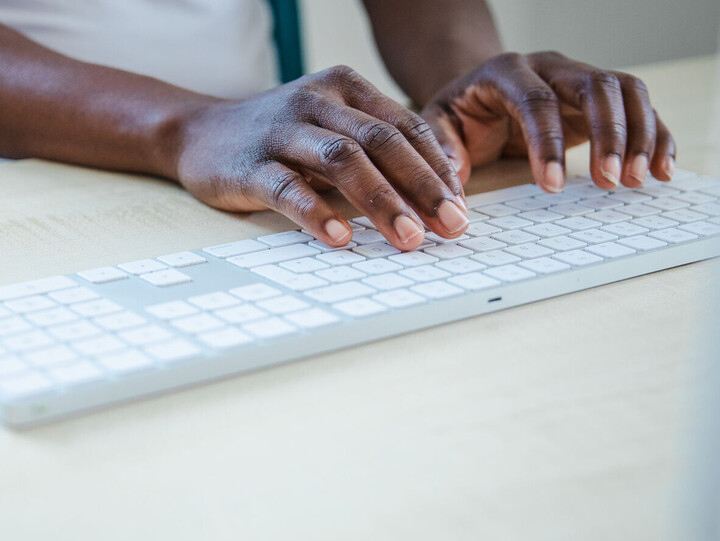 Person, die auf Computertastatur etwas tippt