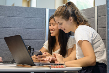 Zwei Studierende mit Laptops in Lernecke