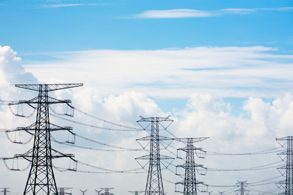 Ein Stromnetz und Strommasten, die KI-Rechenzentren mit Energie versorgen.