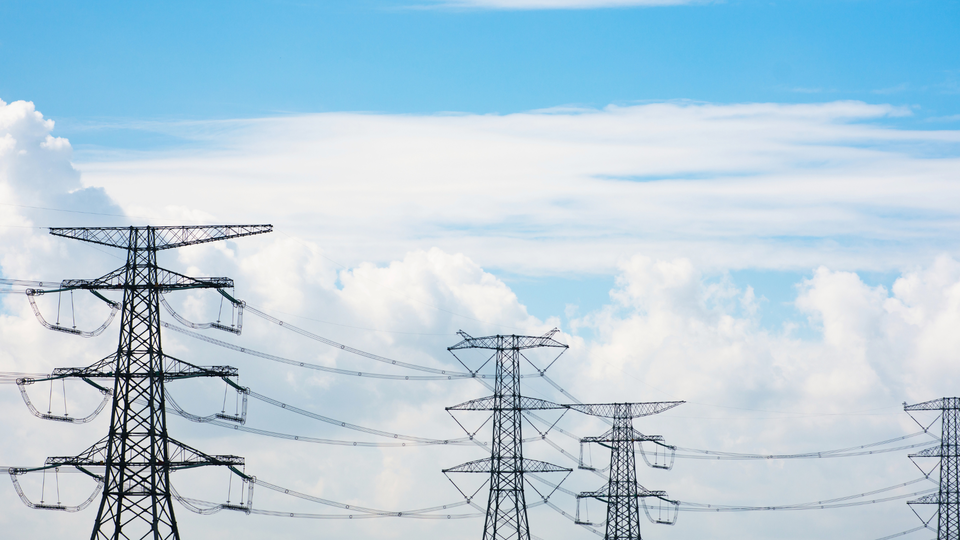 Ein Stromnetz und Strommasten, die KI-Rechenzentren mit Energie versorgen.