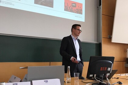 Mann hält einen Vortrag im Vorlesungsraum