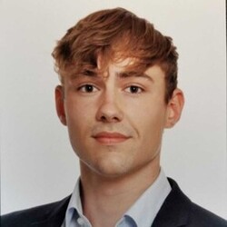 Timon Maaß has short blond hair and wears a blue suit