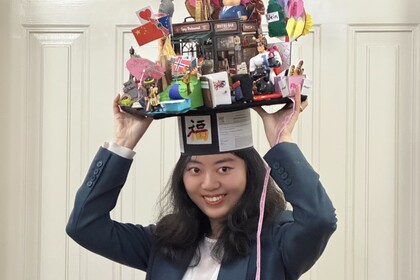 Porträt von Guzi Huang mit einem Doktorhut auf dem Kopf