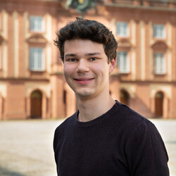 Timon Martens Timon Martens has brown hair and wears a black shirt.