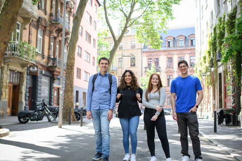 Vier lachende Studierende auf einer verkehrsberuhigten Straße im Mannheimer Jungbusch
