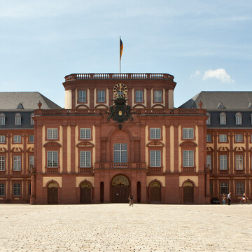 Das Mannheimer Barockschloss und der Ehrenhof unter blauem Himmel.