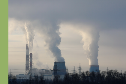 Industriegebiet mit dampfenden Türmen vor bewölktem Himmel