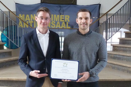 Zwei Männer mit IPSERA-Award in den Händen im Schloss