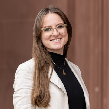 Julia Koziarowski wearing a black shirt and white blazer.
