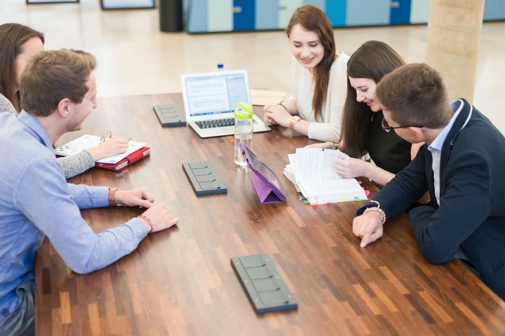 Students with learning materials sitting around a table