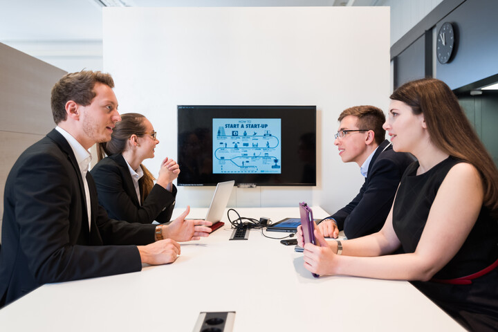 Personengruppe an Tisch mit Bildschirm
