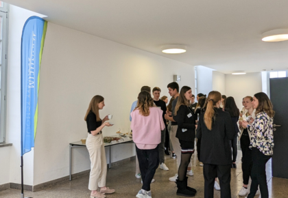 Studierende am Networken und Häppchen essen