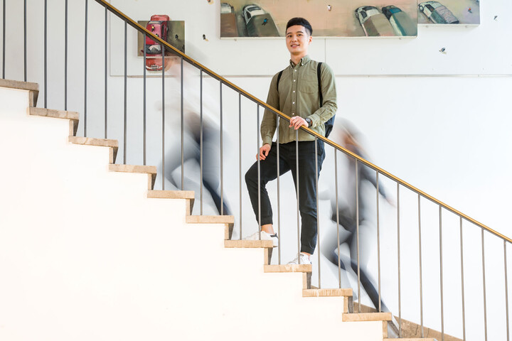 Person steht auf Treppe, dahiner sind verschwommene Schatten