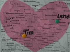 Auf einer Deutschlandkarte wurden zwei bunte Stecknadeln gesetzt und mit "Tim" beziehungsweise "Lena" beschriftet. Ein auf die Karte gemaltes rotes Herz schließt beide Orte ein.