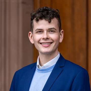 Felix Haas. Die Person trägt einen blauen Sakko.