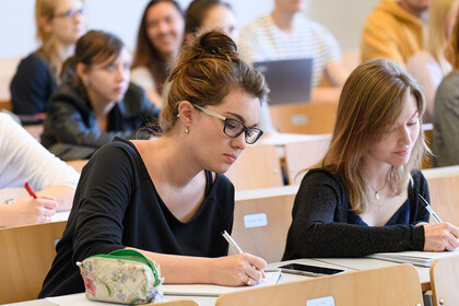 Studentinnen schreiben bei einer Vorlesung mit.