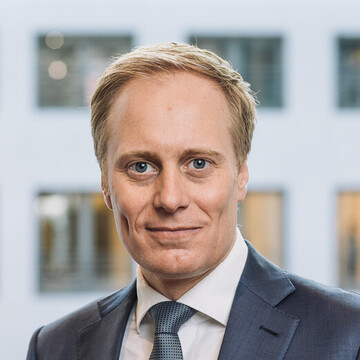 Wilhelm Schmundt hat kurze blonde Haare und trägt ein weißes Hemd, einen blauen Anzug und Krawatte