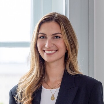 Elisa Sauerbier hat lange blonde Haare. Sie trägt ein helles Oberteil und ein dunkelblaues Jackett.
