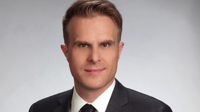 Prof. Stahl has short hair and wears a suit and tie.