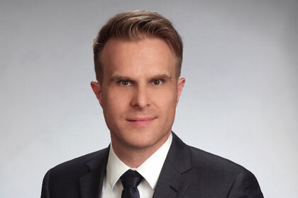 Prof. Stahl has short hair and wears a suit and tie.