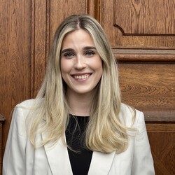 Fenja Ankele has long blonde hair and wears a black top and a beige blazer