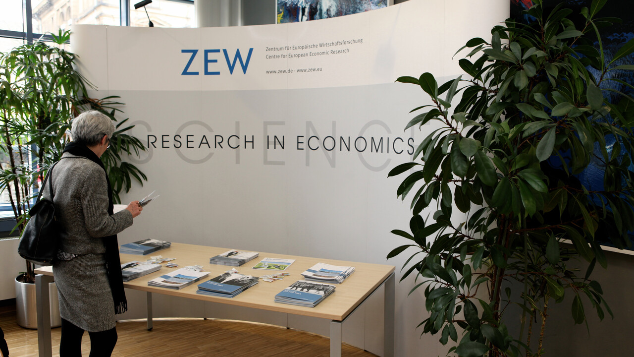 Infostand der ZEW. Eine Person steht davor und schaut sich ein Infoheft an