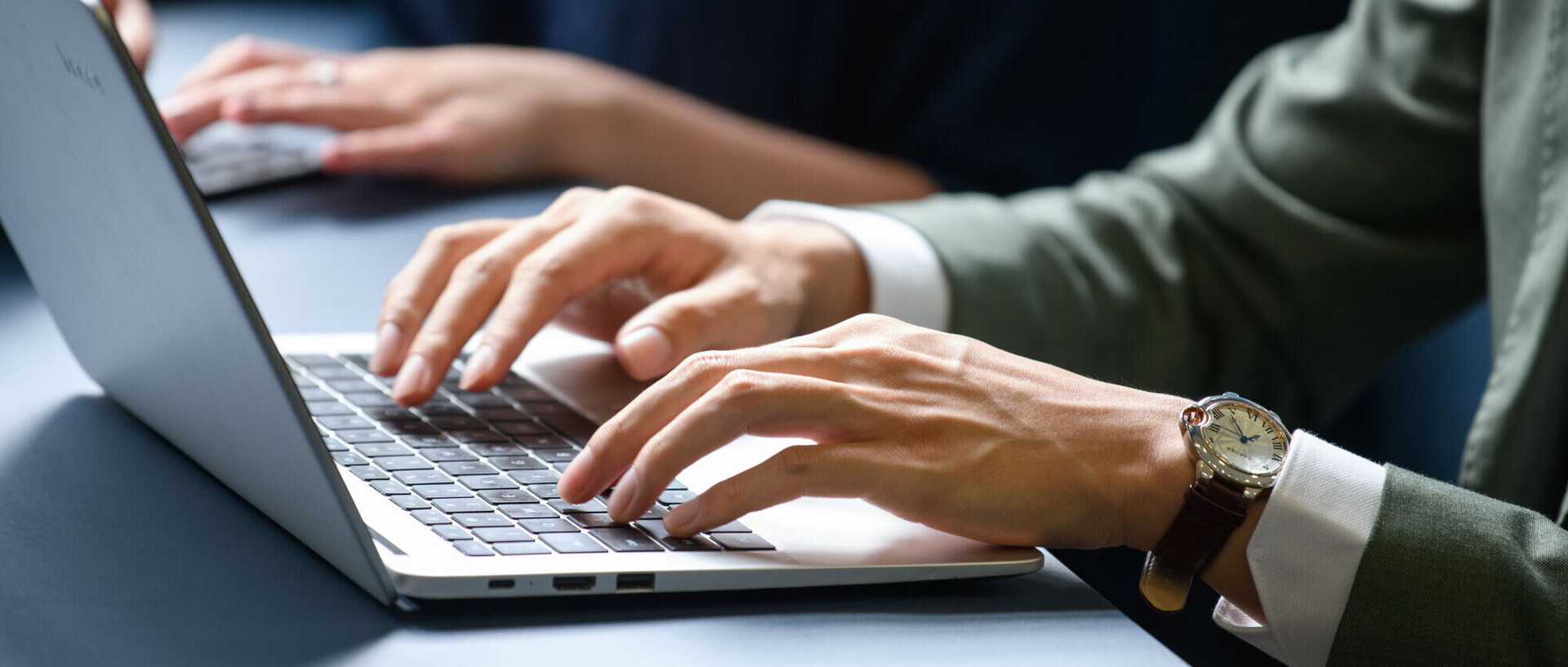 Hände tippen auf Laptops.